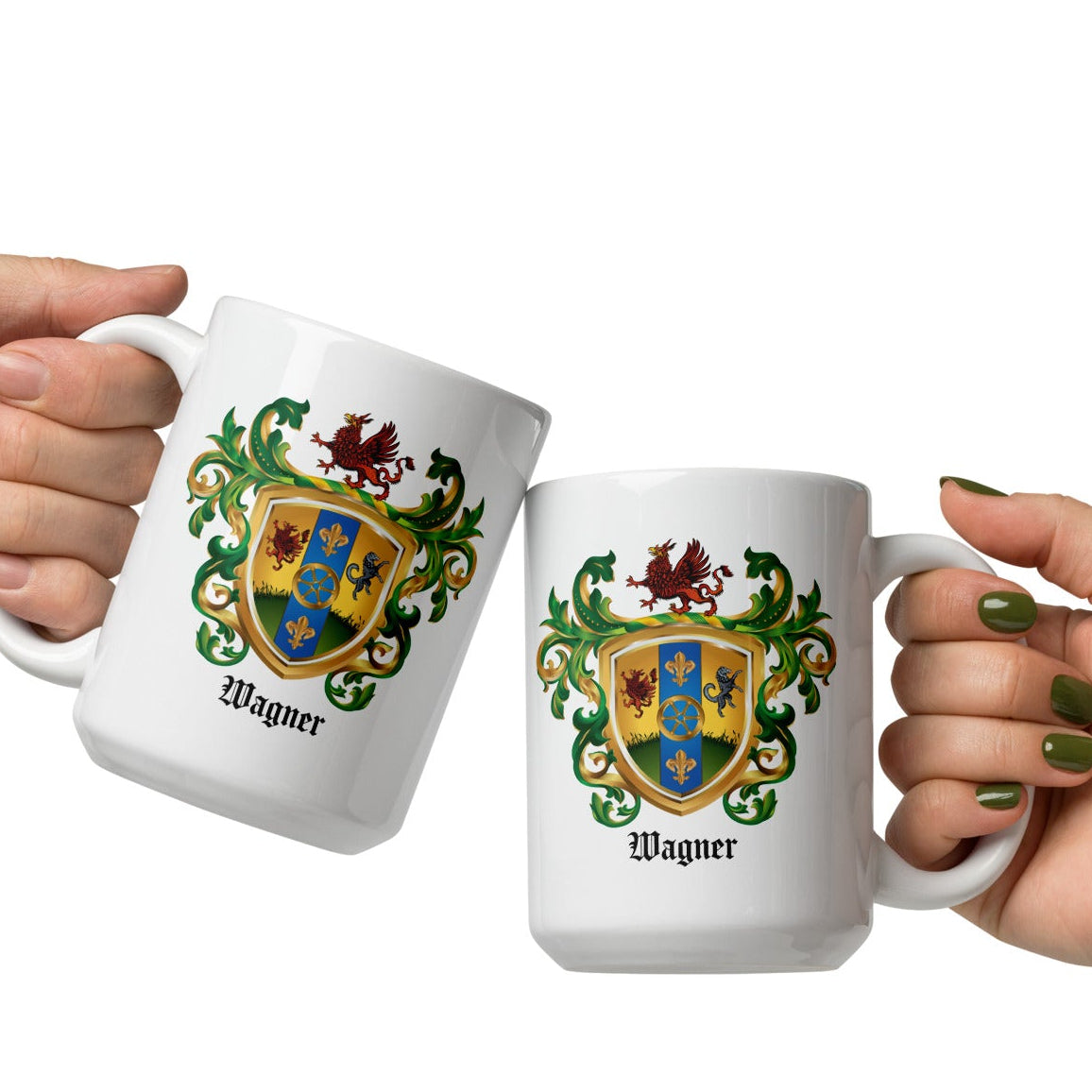 Two hands holding white ceramic mugs with a colorful family crest design and the name 'Wagner' printed below, set against a plain white background.