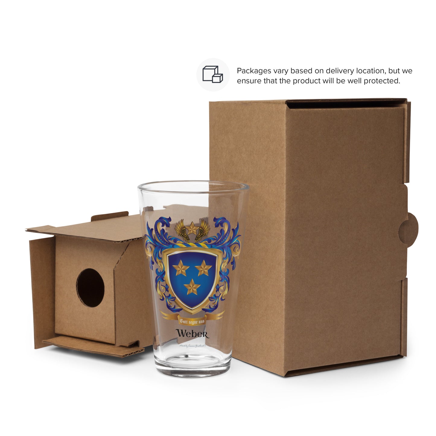 A clear drinking glass with a blue and gold   Weber Family Crest crest design stands in front of brown cardboard packaging boxes on a white background. A small text note at the top says packaging varies based on delivery location.