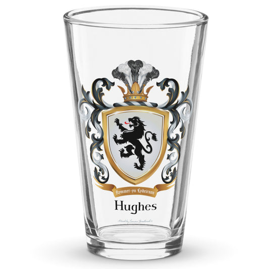 A clear classic pint beer glass on a white background, printed with the Welch Hughes Family Crest featuring a featuring a black lion on a white shield.
