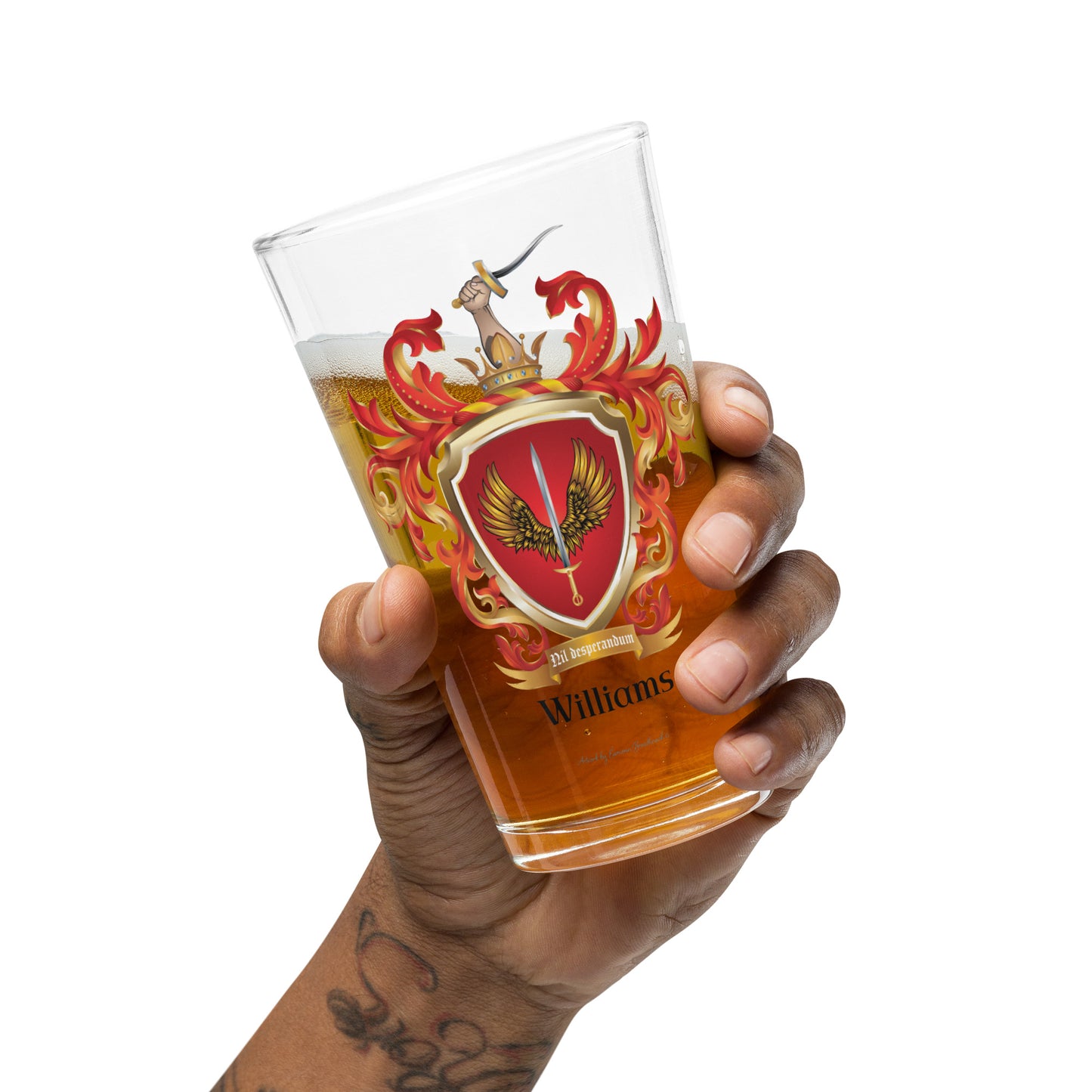 Hand holding a Williams family Crest pint beer on a white background