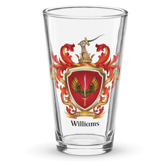 Williams Family Crest pint glass against a a white background with the coat of arms on the glass showing a sword between two golden wings on a red shield and a hand with a sword coming out of a crown at the top on the crest 