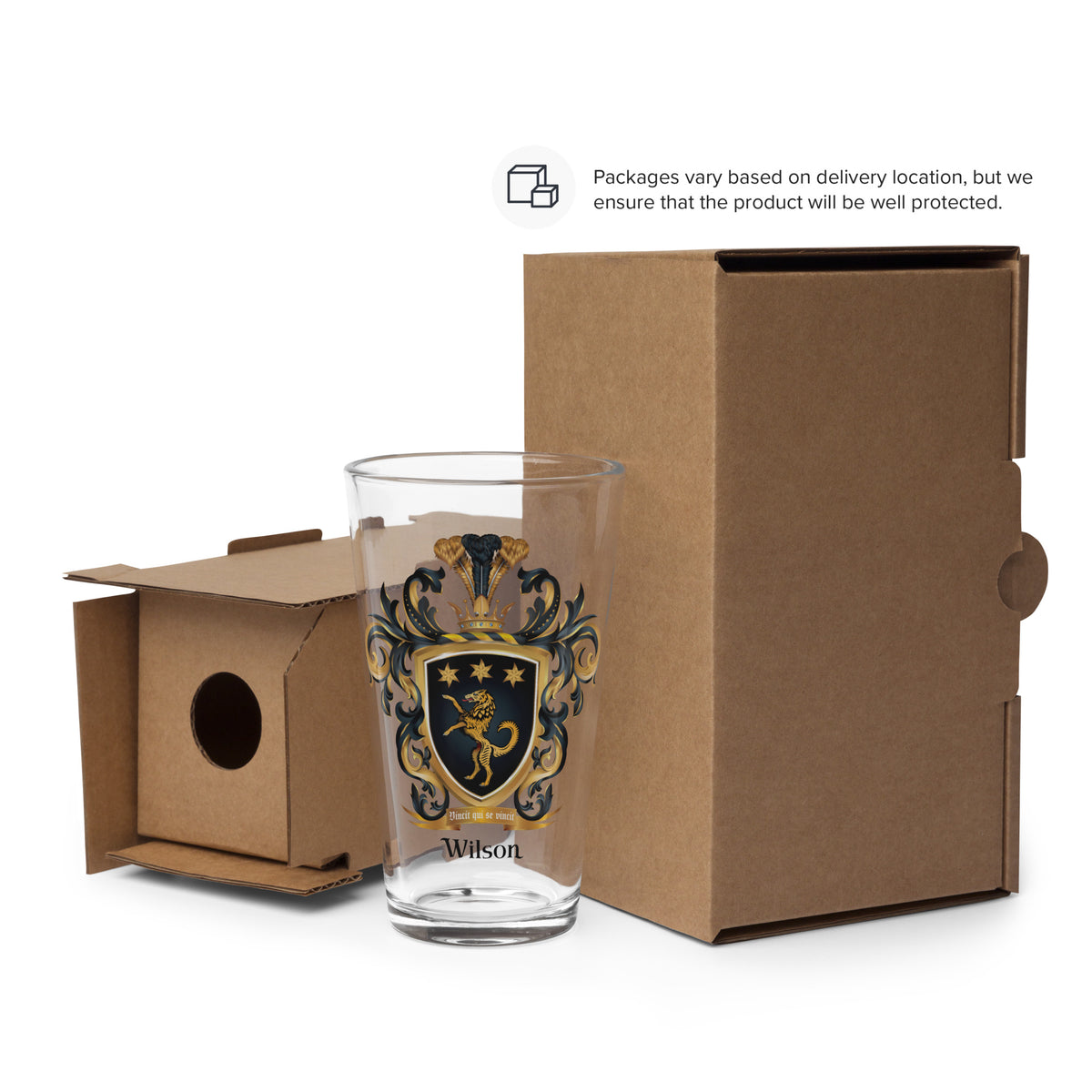Glass with a coat of arms design and 'Wilson' family crest in front of a cardboard box.