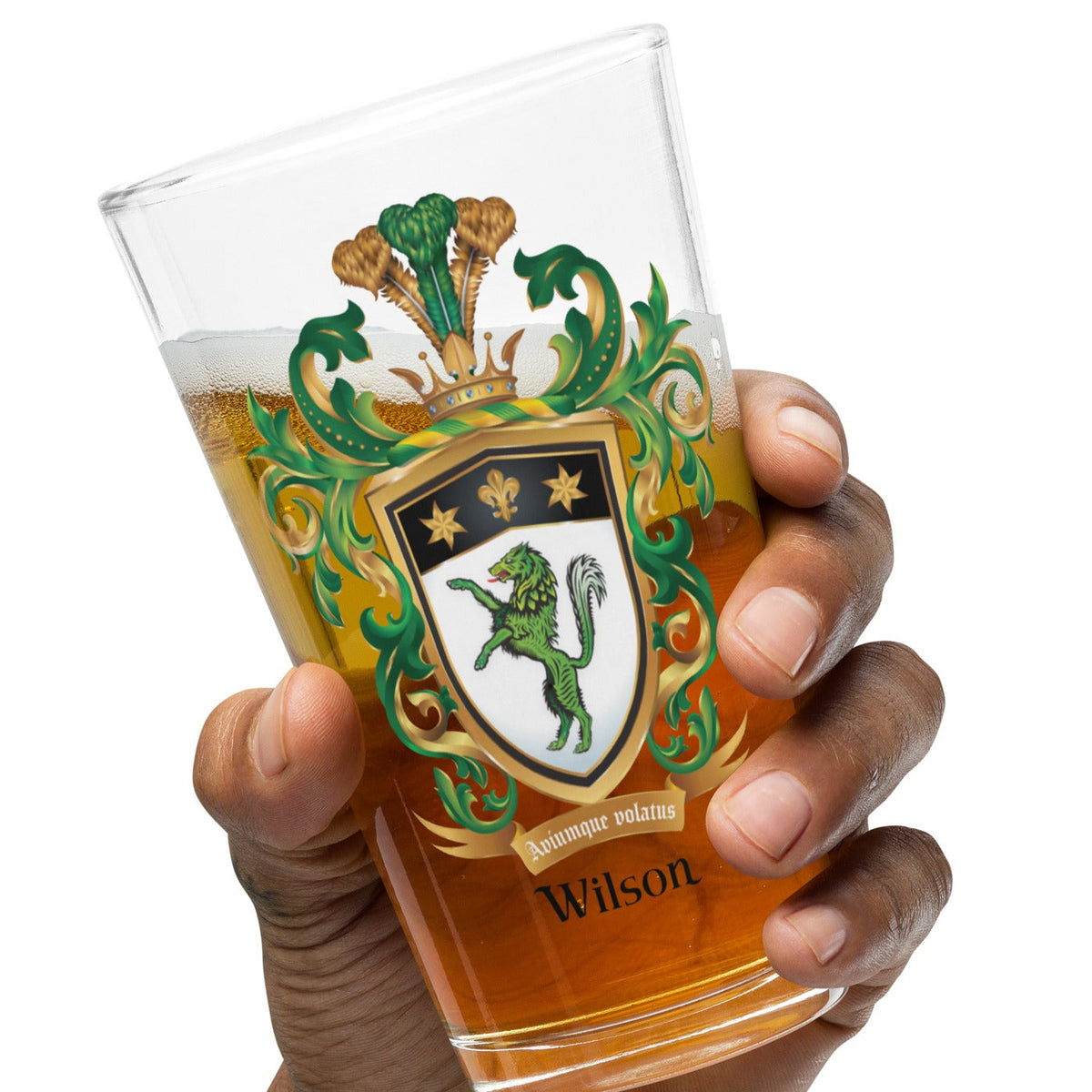 A hand holding a pint glass with Wilson Family Crest featuring the green wolf version