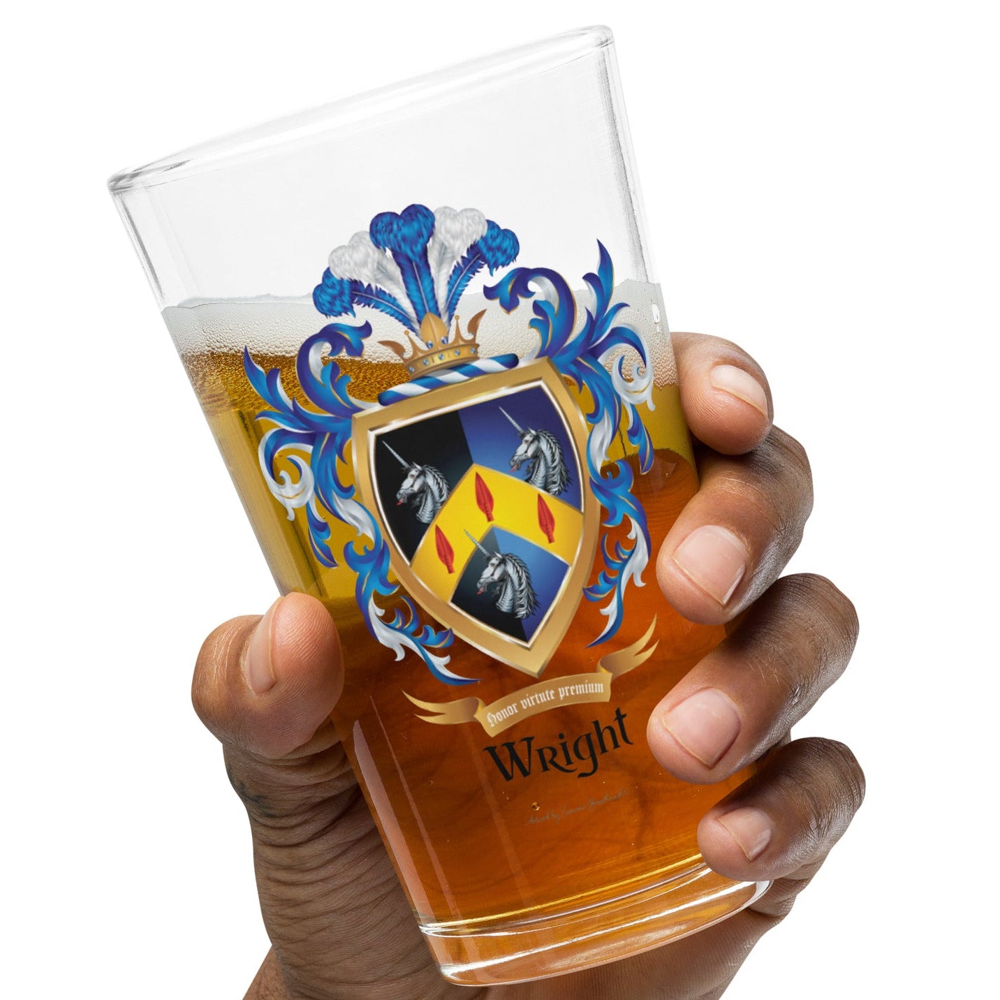 A hand holding a clear pint glass with a printed coat of arms and the name 'Wright' on the front, partially filled with an amber drink, against a plain white background.