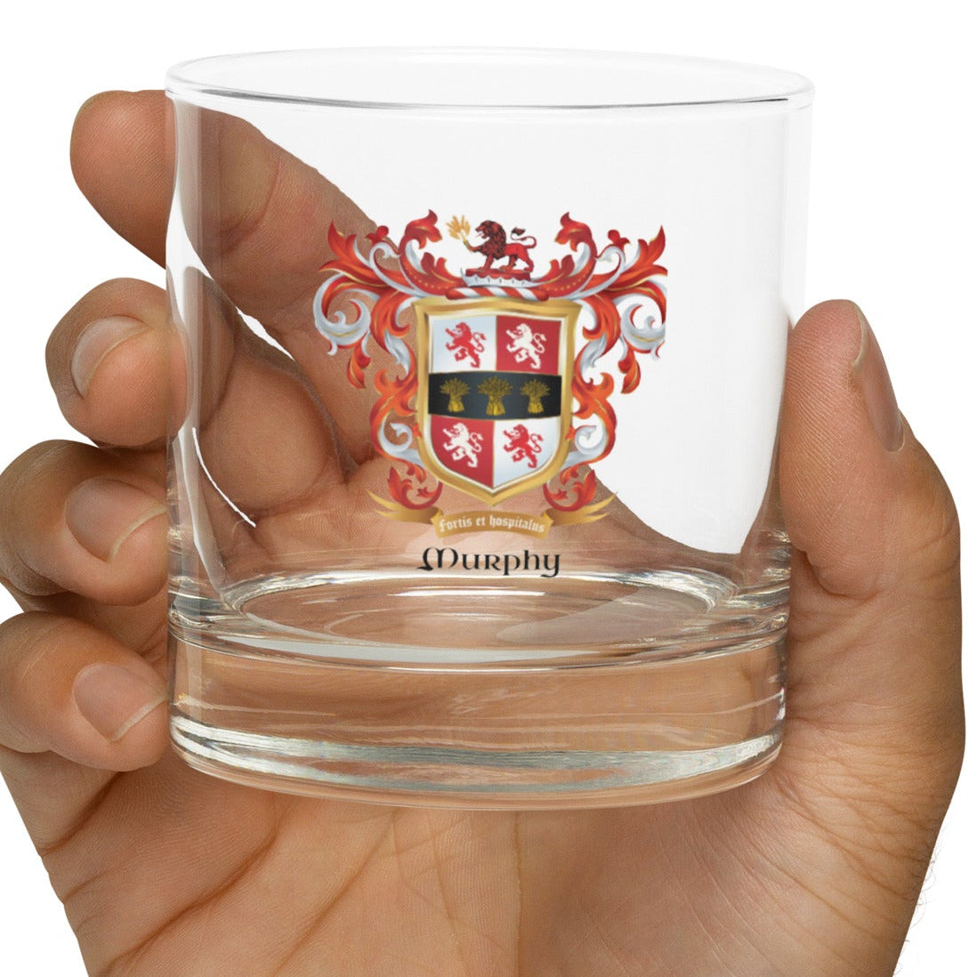 Hand holding a Murphy Family Crest rocks glass on a white background